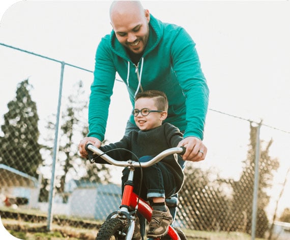 Father teaching son how to ride a bike.